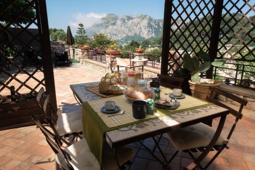 una mesa en un balcón con vistas a la montaña en La casa di Armando, en Capri