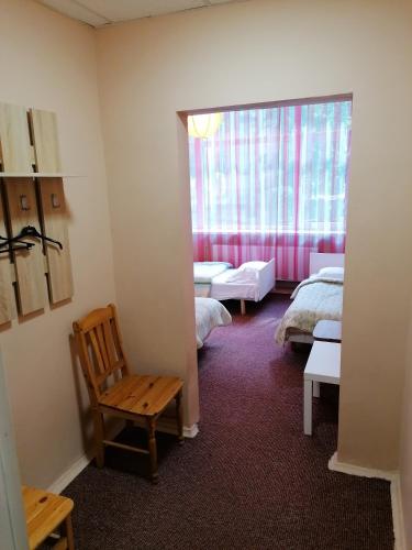 a room with two beds and a chair and a window at Minhauzena Unda in Saulkrasti