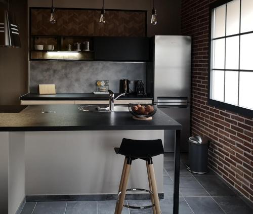 a kitchen with a counter and a sink and a refrigerator at La Gourgasse Vieille in Béziers