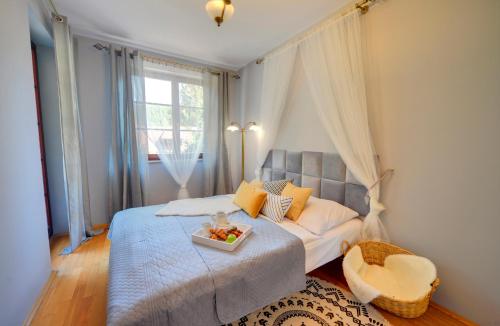 a bedroom with a bed with a tray of fruit on it at Apartamenty Sun Seasons 24 - Rezydencja Pod Świerkami Centrum in Karpacz