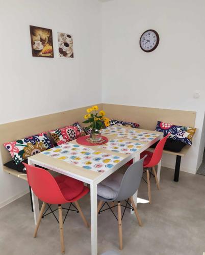 a table with chairs and a vase of flowers on it at Penzion ENO in Kelčany