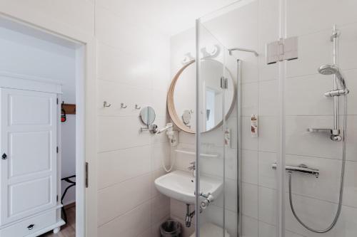 a bathroom with a shower and a sink and a mirror at Hotel Mörbischerhof in Mörbisch am See