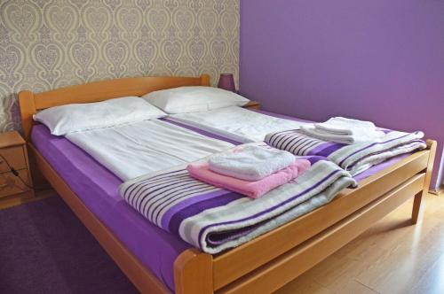 a bed with blankets and pillows on top of it at Apartments Vila Vrdnik in Vrdnik