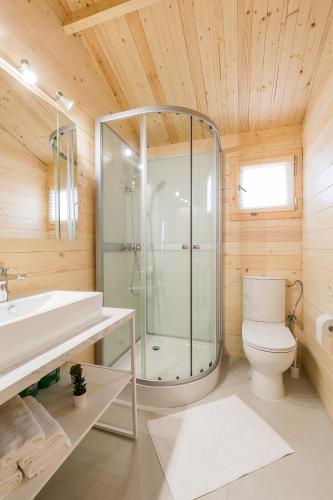 a bathroom with a shower and a toilet and a sink at Domki z Papieru in Polańczyk