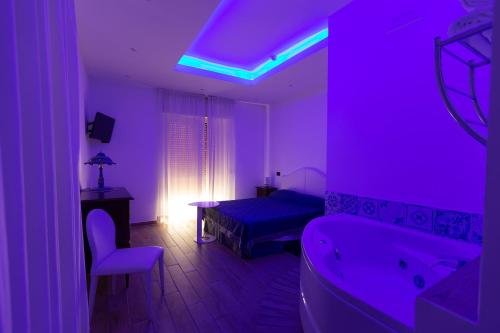 Hotel Vietri Coast في فيتري: غرفة أرجوانية مع غرفة نوم مع سرير وحوض استحمام