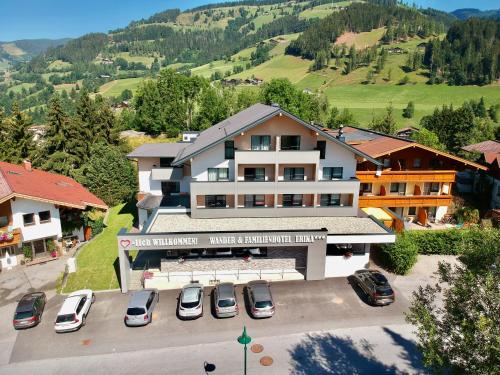 une vue aérienne sur un hôtel avec des voitures garées dans un parking dans l'établissement Wanderhotel Erika, à Wagrain