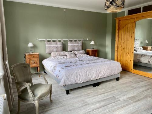 a bedroom with a bed and a chair and a mirror at The Great View in Bouillon
