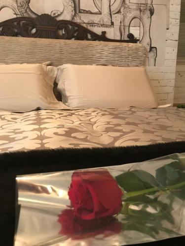 a red rose is sitting on a bed at Suite Romantica Fuga in Roncone