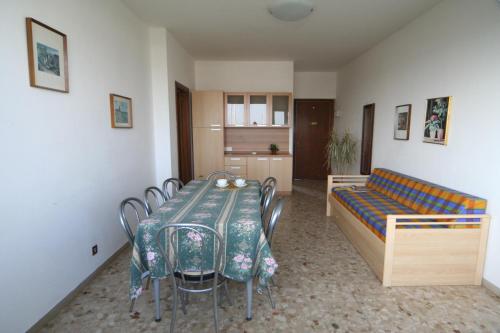 Habitación con mesa, sillas y sofá en Levante, en Lignano Sabbiadoro
