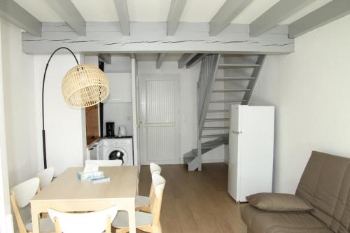ein Wohnzimmer mit einem Tisch und einer Treppe in der Unterkunft Anglet : Duplex dans résidence avec piscine in Anglet