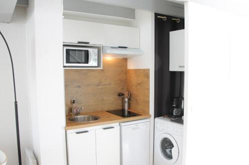 een kleine keuken met een wastafel en een magnetron bij Anglet : Duplex dans résidence avec piscine in Anglet