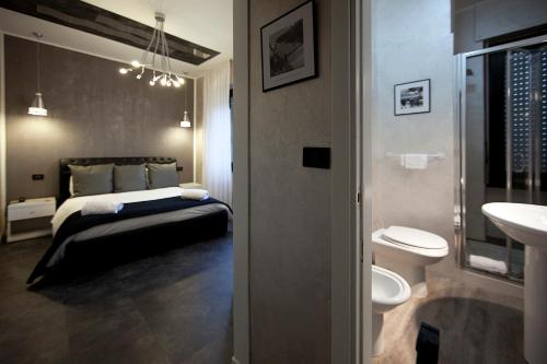1 dormitorio con cama, aseo y lavamanos en Piccolo Hotel Allamano, en Grugliasco