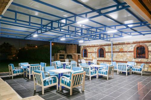 a restaurant with blue tables and chairs at Sunset Village in Didim