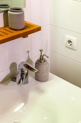 a bathroom sink with a soap dispenser on a counter at Devesa Park Apartment with Private Parking in Girona