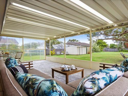 a large screened in porch with a couch and a table at Sea Bird in Culburra Beach