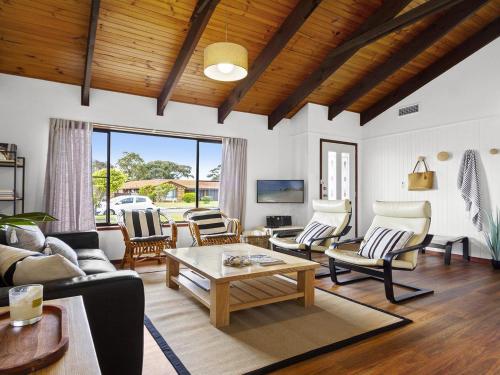 a living room with couches and chairs and a table at Sea Bird in Culburra Beach