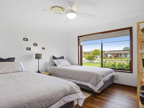 a bedroom with two beds and a large window at Sea Bird in Culburra Beach