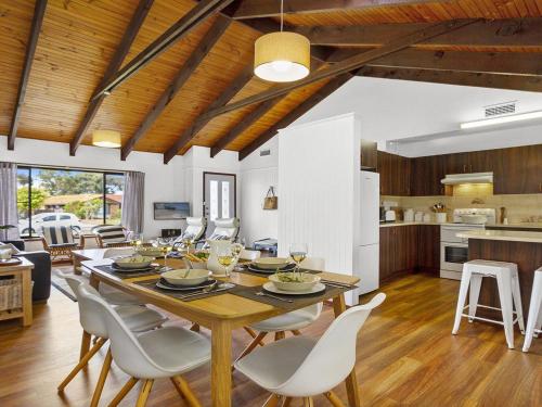 a dining room and kitchen with a table and chairs at Sea Bird in Culburra Beach