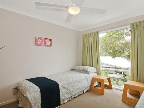 un dormitorio con una cama y una ventana en Sea Whispers, en Callala Beach