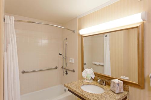 y baño con lavabo, bañera y ducha. en Holiday Inn Long Beach - Airport, an IHG Hotel en Long Beach