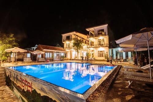 a swimming pool in front of a house at night at Jade Hotel in Phong Nha