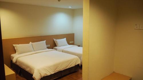 a room with two beds with white pillows at 906 Hotel Melaka Raya in Melaka