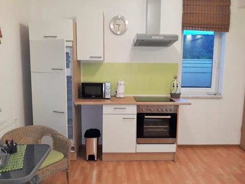 a small kitchen with a stove and a microwave at Ferienwohnung FLAIR in Zella-Mehlis