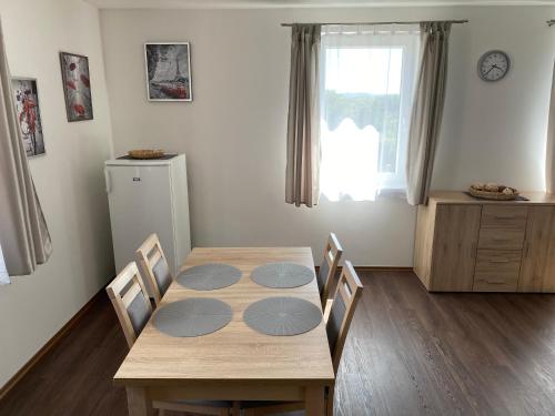 ein Esszimmer mit Tisch und Stühlen und einem Fenster in der Unterkunft Apartmány Krupka in Krupka