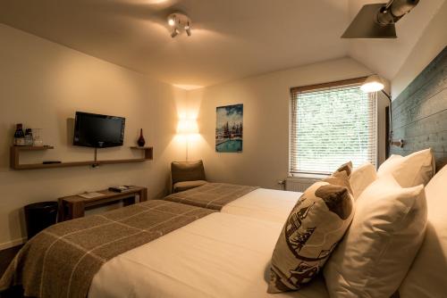 a hotel room with a bed and a tv at Hotell Granen in Åre