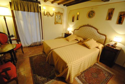 a bedroom with a bed and a table and a window at Torre Sangiovanni Albergo e Ristorante da Rosary in Todi