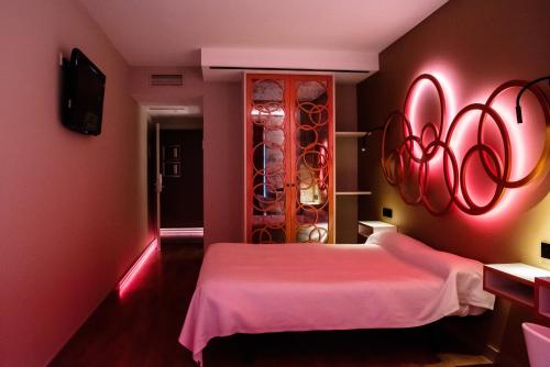 a pink room with a bed and a mirror at Hotel Centro Los Braseros in Burgos