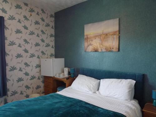 - une chambre avec un lit et une photo sur le mur dans l'établissement The Chequers, à Great Yarmouth