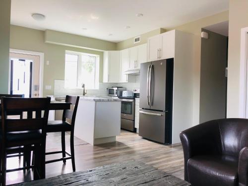 a kitchen with a refrigerator and a table and chairs at Downtown Whitehorse Deluxe 2 Bedroom Condo in Whitehorse