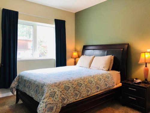 a bedroom with a large bed and a window at Downtown Whitehorse Deluxe 2 Bedroom Condo in Whitehorse