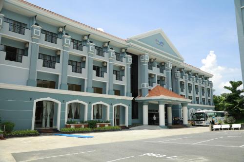 a large building with a bus parked in front of it at Ninh Kieu Riverside Hotel in Can Tho