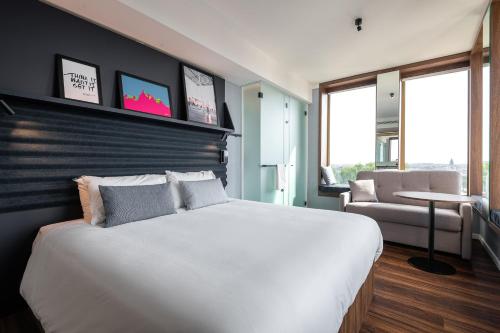a bedroom with a large white bed and a chair at A-STAY Antwerp in Antwerp
