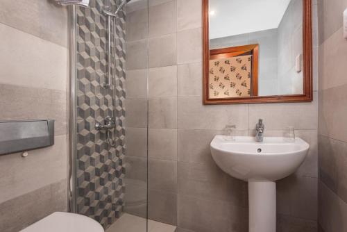 La salle de bains est pourvue d'un lavabo, de toilettes et d'une douche. dans l'établissement Hotel Castille, à La Valette
