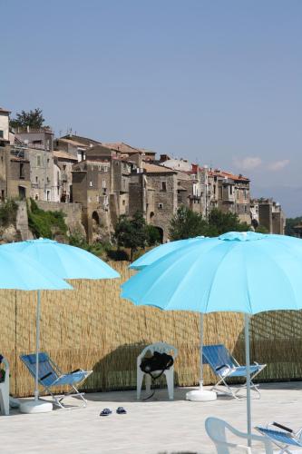a group of chairs and umbrellas on a beach at Le Rocce in SantʼAgata deʼ Goti