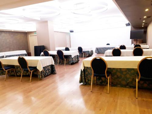 a conference room with tables and chairs and a stage at Hotel Centro Los Braseros in Burgos
