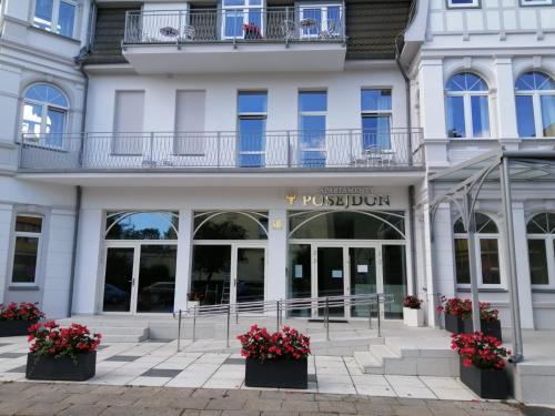a white building with a pinksdaindain sign on it at APARTAMENTY POSEJDON in Świnoujście