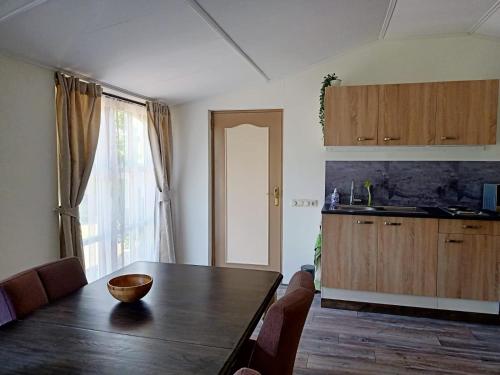 een keuken en eetkamer met een houten tafel bij Bij de Vlaamse Schuur in Wagenberg