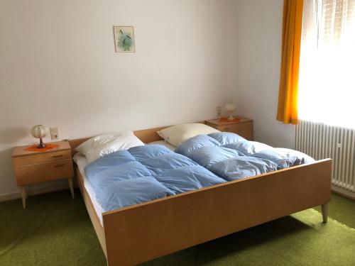 a bed with blue sheets on it in a bedroom at Sabine’s Gästehaus in Übereisenbach
