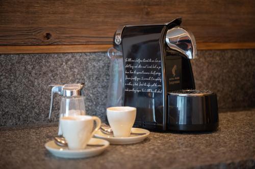 a coffee maker and two cups on a counter at Gipfelhaus Magdalensberg in Sankt Veit an der Glan