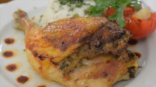 a piece of chicken on a plate with rice and vegetables at Hotel Club Tisza in Lakitelek
