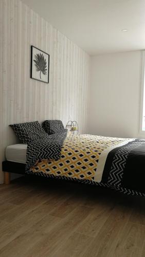1 dormitorio con 1 cama con sábanas blancas y negras en Le coryphée : Appartement en centre ville à Abbeville, en Abbeville