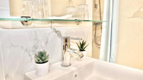 a bathroom sink with a glass shelf above it at Hotel le Nice Etoile in Nice
