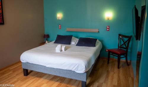 a bedroom with a white bed with a red chair at Logis - Hotel & Restaurant La Corne d 'Abondance in Bourgthéroulde