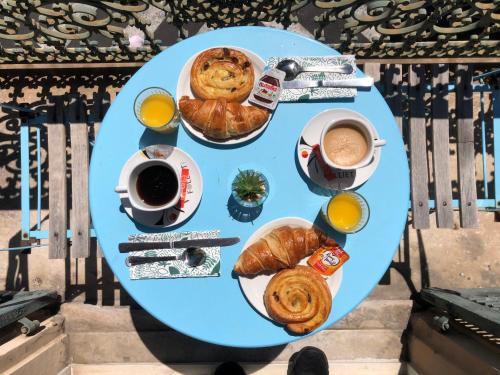 a table topped with plates of food and a cup of coffee at Hotel le Nice Etoile in Nice