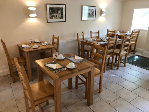 a dining room with wooden tables and chairs at The Old Mill Bed and Breakfast in Bere Regis