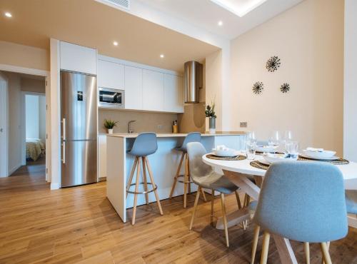 a kitchen and dining room with a table and chairs at San Martín Suites Apartments in Seville